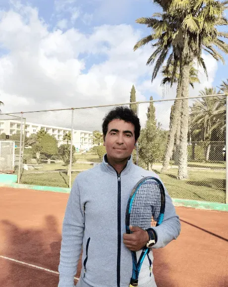 Said Akhabbar, directeur technique du club, raquette à l’épaule devant un court en terre battue
